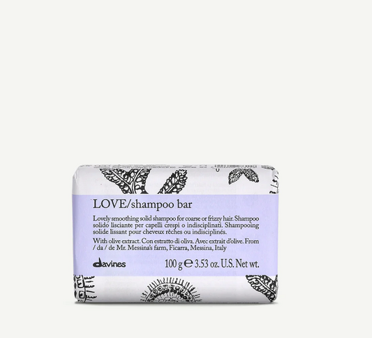 A solid shampoo bar with a decorative pattern and text indicating it is a LOVE brand product, with olive extract, from Italy.