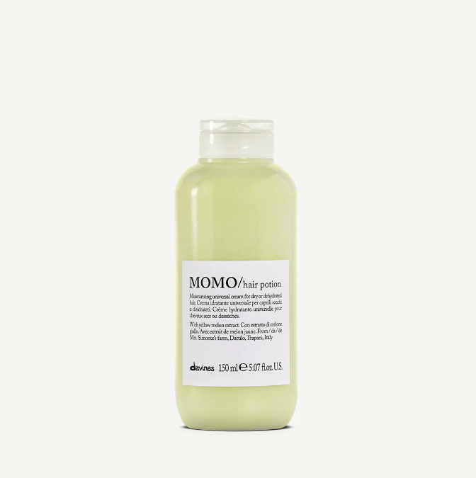A bottle of MOMO Hair Potion, a moisturizing hair lotion by Davines. The bottle is clear with a white label and cap, and it contains a light green liquid.